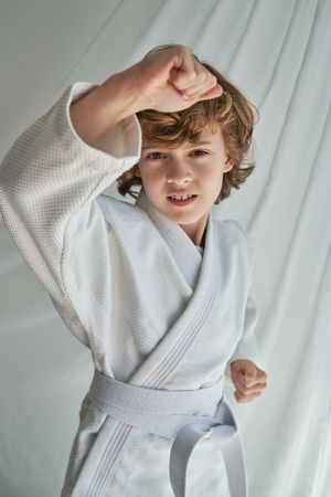 Serious boy in kimono doing karate