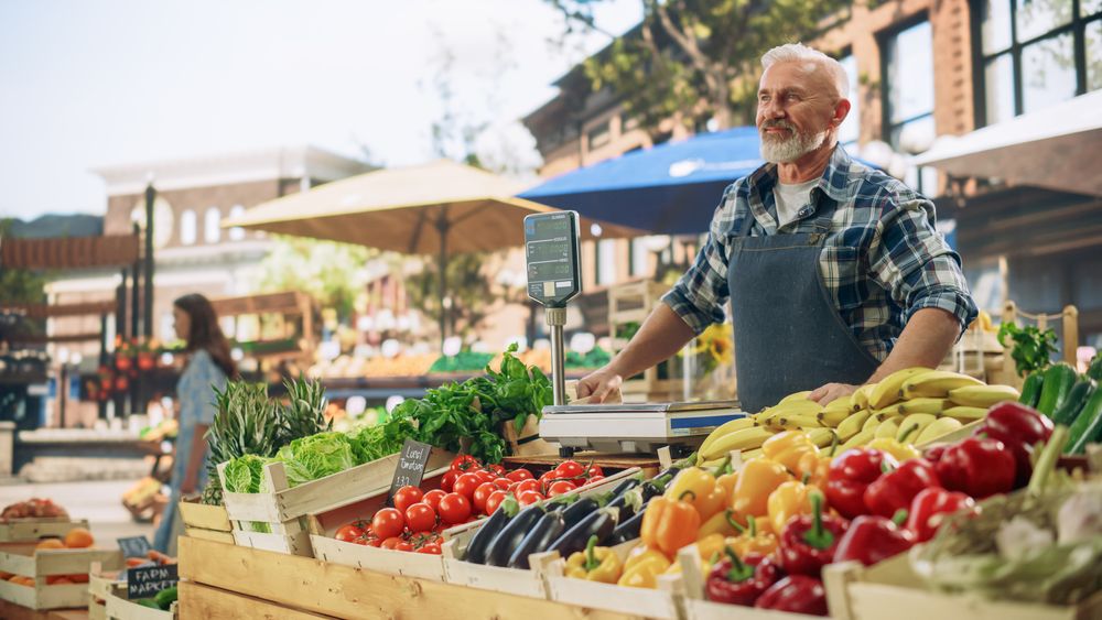 Cheerful Street Vendor Running a Small Farm Market Business, Selling Sustainable Fruits and Vegetables.