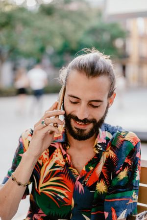 Bearded man talking on smartphone and looking away