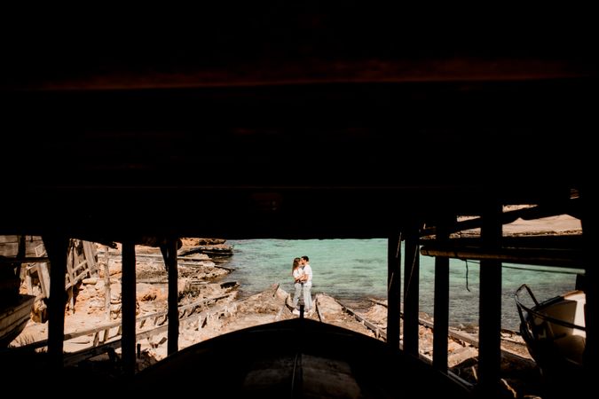 Amorous couple hugging on coastal pier