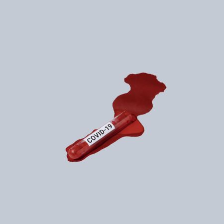 Vial of blood labelled with “COVID-19” spilled on light background