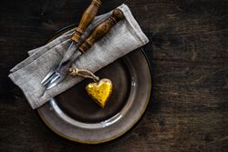 St. Valentine's day concept with golden heart ornament on table setting with copy space
