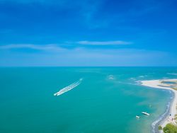 Aerial shot of boat going through water in clear Brazilian waters