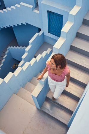Woman walking downstairs on modern blue building