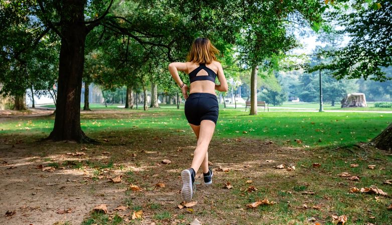 Female athlete running through a park