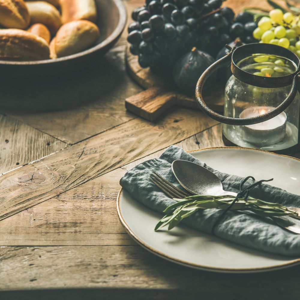 Fall holiday table decoration setting, with grapes, bread, and candle, copy space, square crop