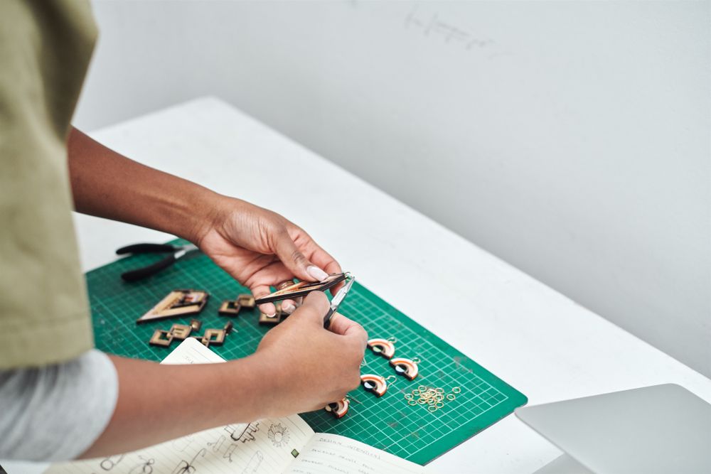 Jewelry designer carving pieces to create earrings