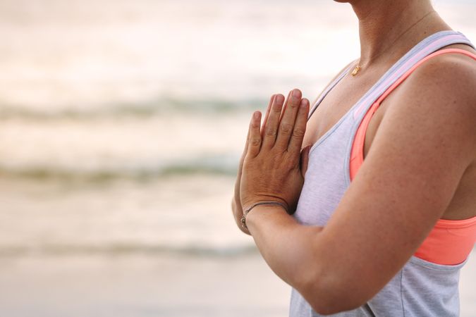 Side view of a woman practicing meditation at the beach