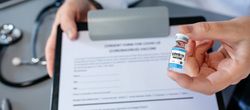 Female doctor's hand showing coronavirus vaccine vial