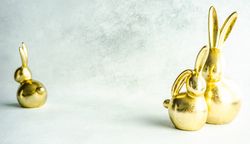 Easter holiday card concept with three golden rabbits