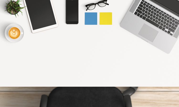 Modern workplace with laptop, coffee cup and smartphone or tablet copy space on table background. Top view. Flat lay style.