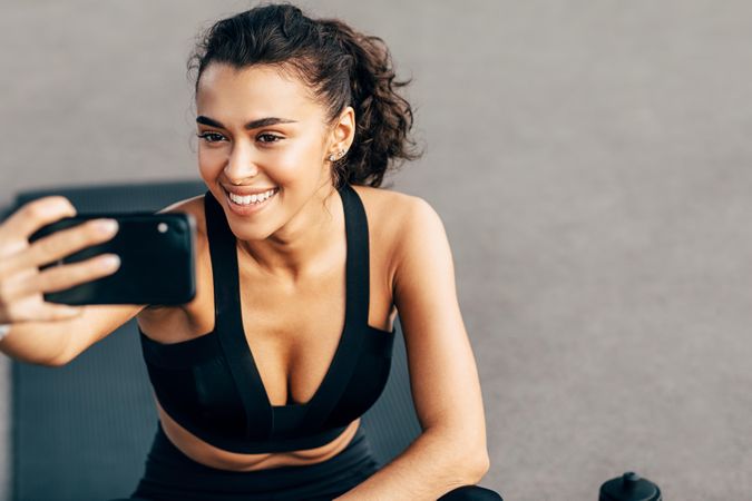 Smiling woman taking a selfie before a workout