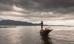 Shan, Myanmar - June, 25 2012: Anonymous fisherman standing on boat