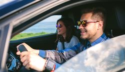 Young man driving a car with his girlfriend