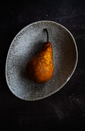 Sweet organic pear fruit in grey bowl