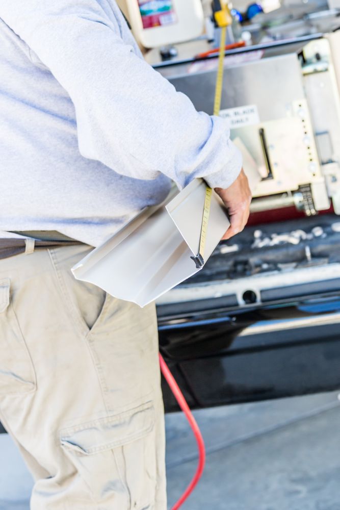 Worker Measuring Rain Gutter Processing Through Seamless Shaping Machine