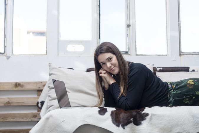 Woman sitting on sofa and using laptop