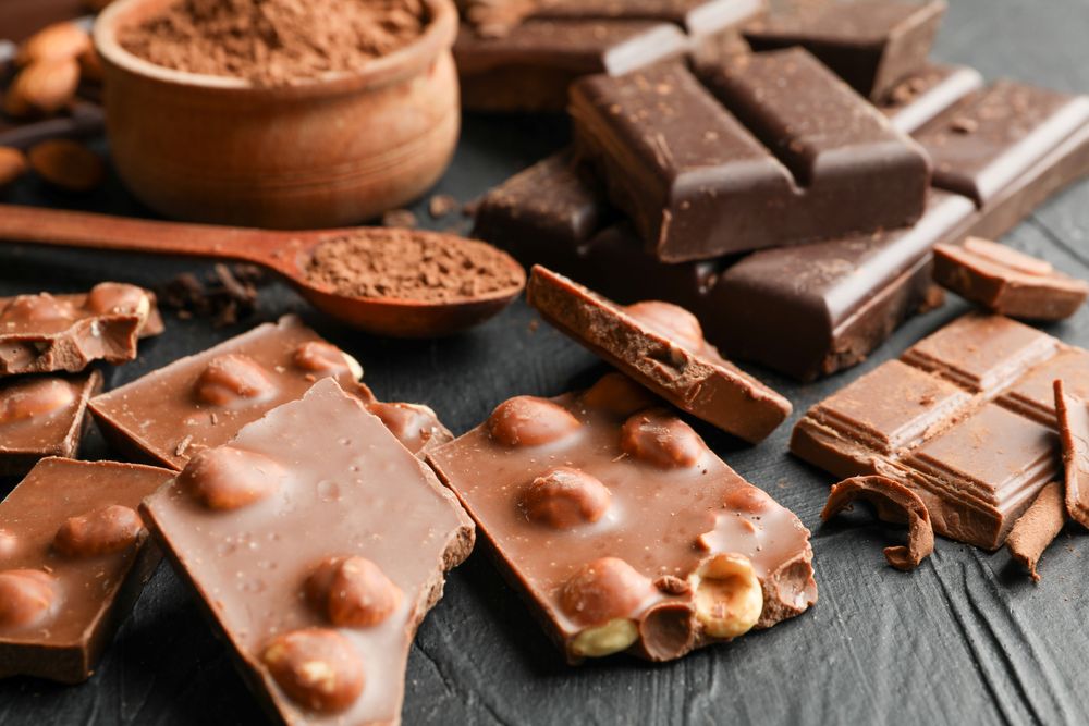Chocolate, melted chocolate and almond on dark background