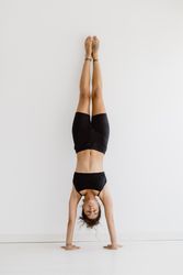 Sportive woman performing yoga pose in room