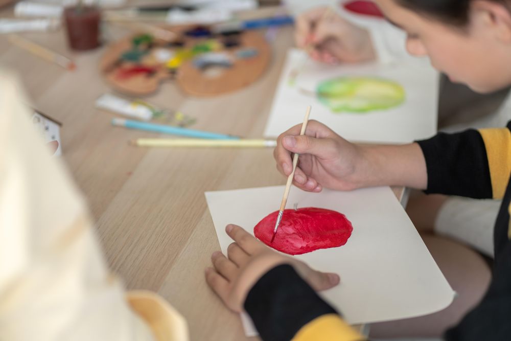 Classroom table with students sitting painting