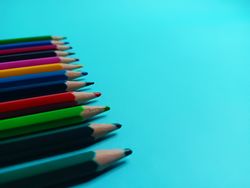 light blue background with wooden color pencils in close up mode