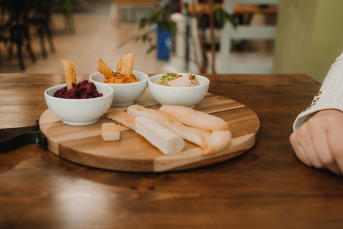Different tasty sauces on round wooden stand