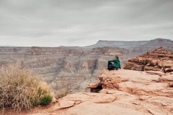 Female relaxing on cliff and admiring picturesque view