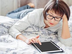 Woman with tablet on bed