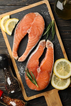 Composition with salmon meat and spices on wooden background, top view