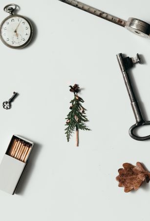 Creative arrangement of vintage items on desk with branch and matches