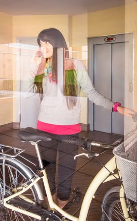 Woman with fixie bike leaving hall behind a glass