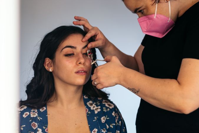 Young woman being made up by a beautician in a makeup studio