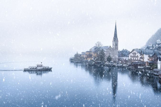 View of Hallstatt town and with a  boat in the lake under snowfall