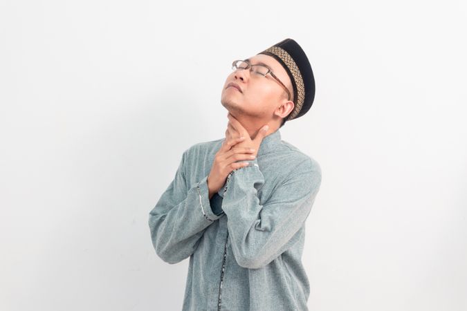 Asian Muslim man touching neck, thirsty gesture during fasting in Ramadan