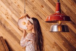 Young woman posing between ceiling lamps
