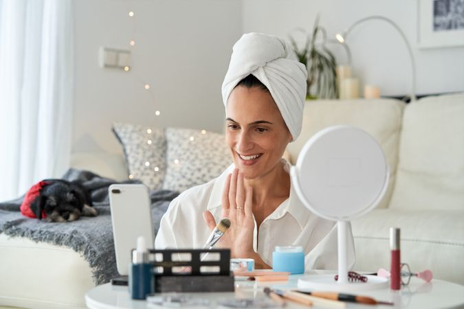 Cheerful woman recording beauty routine tutorial
