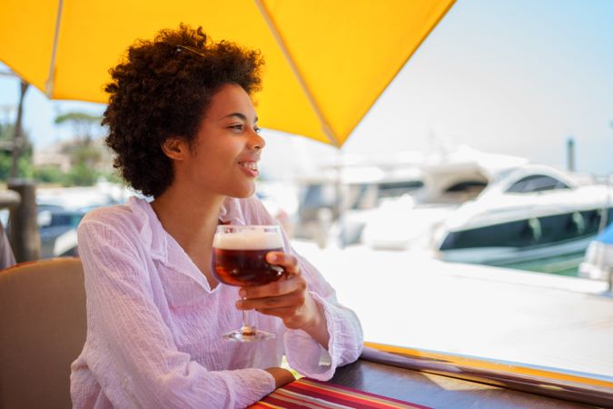 Woman with glass of beer at cafe on the pier