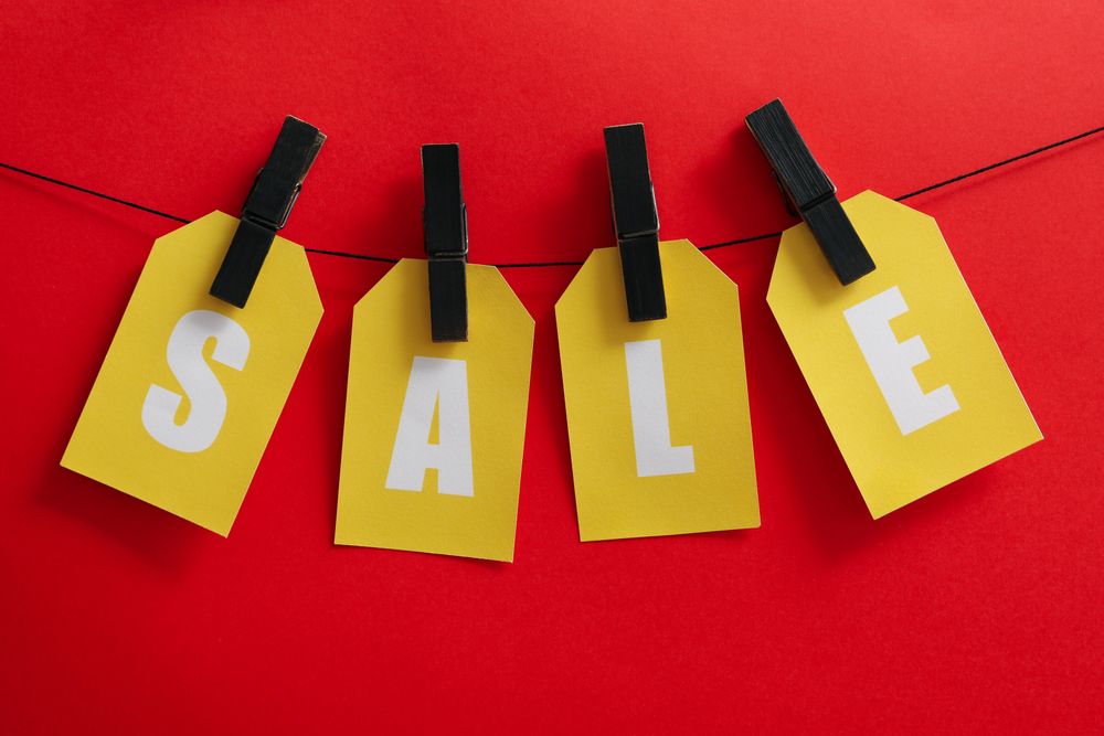 Text Sale hanging on the clothesline on red background