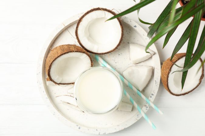 Tray with coconut and milk on wooden background, top view