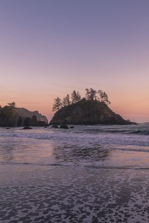 Sunset or sunrise over low tide at a quiet beach, vertical