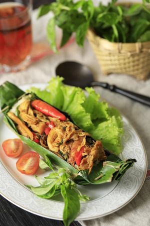 Top view of nasi bakar banana leaf stuffed with chicken and peppers