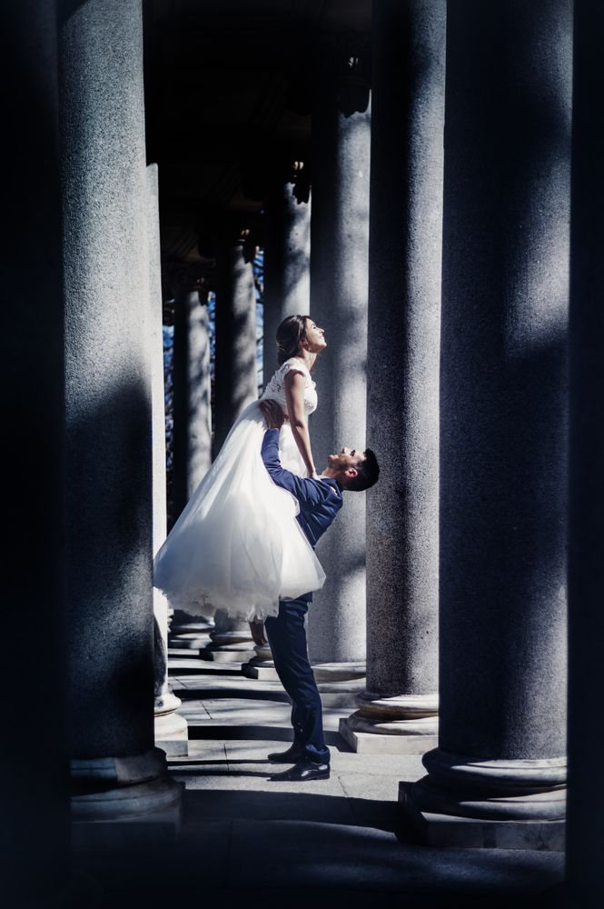 Newly weds having fun between columns
