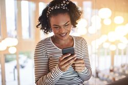 Woman smiling while checking her phone