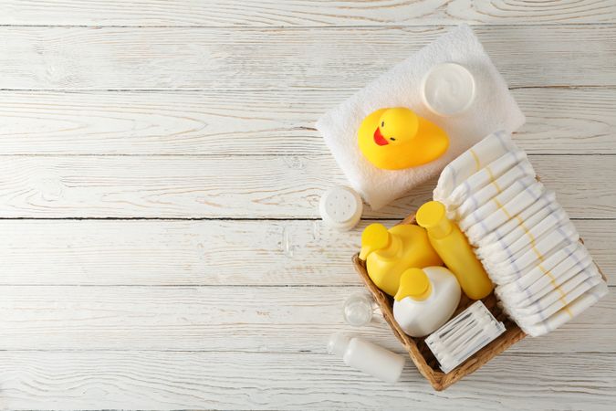 Baby hygiene accessories on wooden background, top view