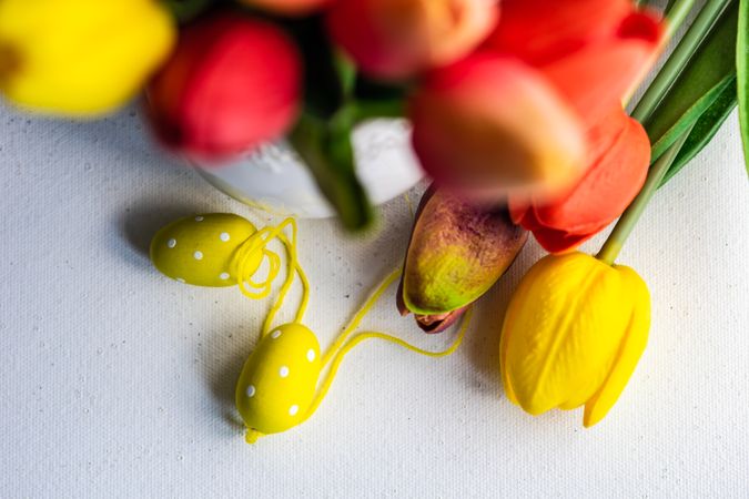 Easter concept of tulips with yellow egg ornaments