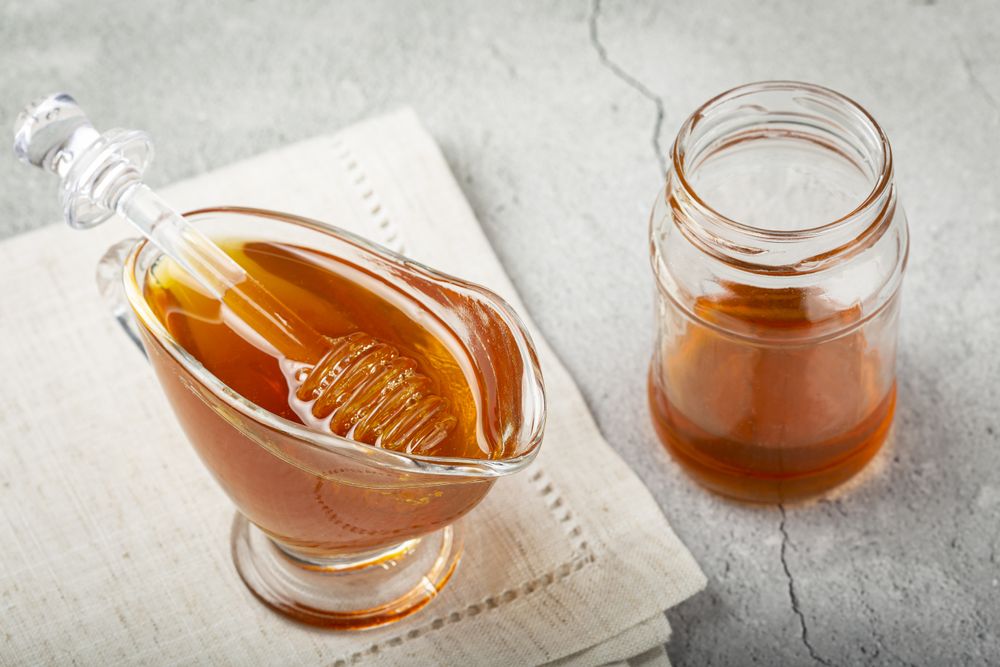 Honey in glass bowl on the table.