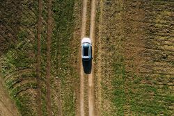 Aerial view of a car crossing a dirt road