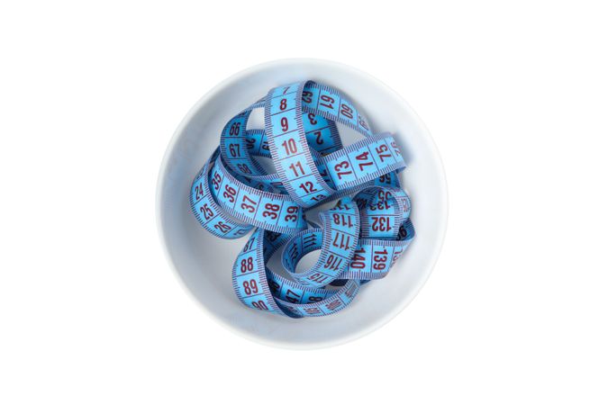 Bowl with measuring tape isolated on blank background
