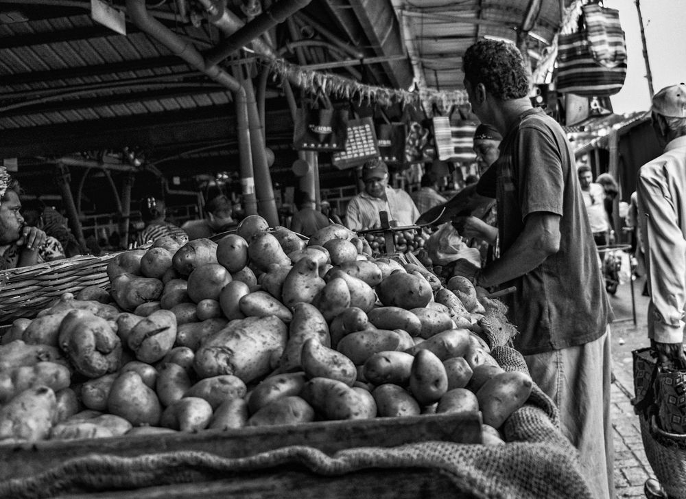 Man selling potatoes at an open air market