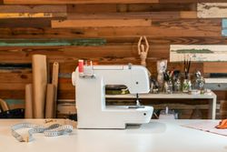 Modern sewing machine on table at fashion studio